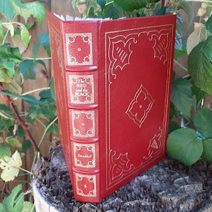 May include: A red hardback book with gold accents and the title "The Red and the Black" by Stendhal.