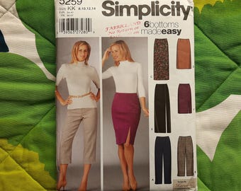 May include: Simplicity sewing pattern 5259 showing a woman in a white turtleneck and a burgundy skirt with a front slit. The pattern includes options for six different skirt styles. The pattern size is KK 8,10,12,14.