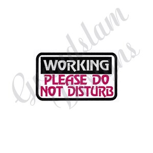 Puede incluir: Un letrero en blanco y negro con el texto "WORKING PLEASE DO NOT DISTURB" en letras rosas.