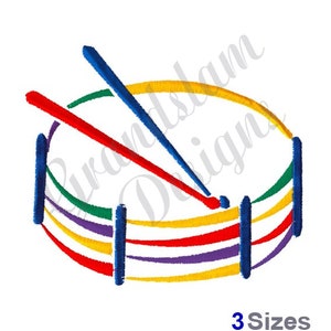 May include: A colorful cartoon illustration of a drum with two drumsticks. The drum is yellow, red, purple, green, and blue. The drumsticks are red and blue.