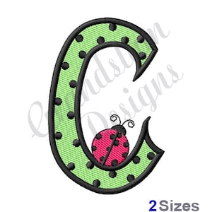 May include: Green letter C with black polka dots and a ladybug with black spots and pink wings.