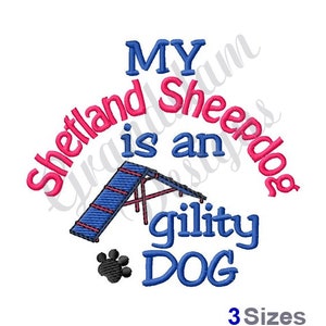 May include: Embroidered design featuring a blue agility dog jump and the text "My Shetland Sheepdog is an agility dog" in pink and blue lettering.