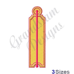 Könnte beinhalten: Ein gestickter Aufnäher in Gelb und Rosa mit einer einzigen vertikalen Linie in der Mitte. Der Aufnäher hat eine abgerundete Oberseite und einen dekorativen Rand.
