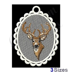 May include: White oval frame with a scalloped edge, containing an embroidered image of a brown deer head with antlers.