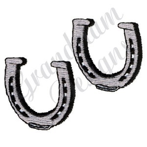 Könnte beinhalten: Zwei silberne Hufeisen mit schwarzen Akzenten. Die Hufeisen zeigen in die gleiche Richtung.