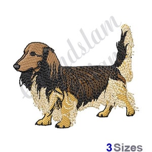 May include: Embroidered design of a brown and black dachshund with a long, flowing tail. The dog is standing on all four legs and has a long, thin body.