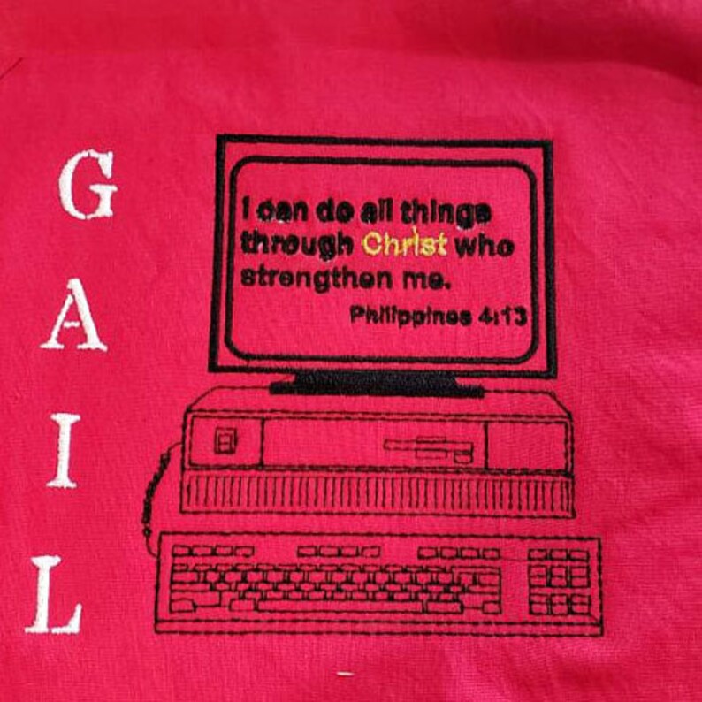 Peut inclure: Broderie sur un t-shirt rouge repr&eacute;sentant un ordinateur vintage avec le texte "Je peux tout faire par Christ qui me fortifie. Philippiens 4:13" et le mot "GAIL" sur le c&ocirc;t&eacute; gauche.