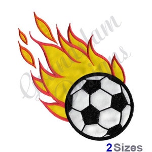 May include: A black and white soccer ball with flames behind it. The flames are yellow and red.