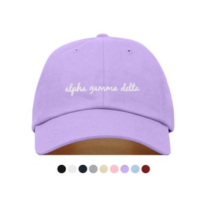May include: A lavender baseball cap with white embroidered text that reads "alpha gamma delta".