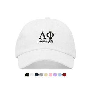 Puede incluir: Gorra de béisbol blanca con letras bordadas en negro "AΦ" y el texto "Alpha Phi" debajo.