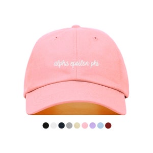 Puede incluir: Una gorra de béisbol rosa con texto bordado en blanco que dice "alpha epsilon phi".