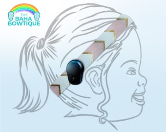 Pode incluir: Um desenho de linha de uma criança usando uma faixa de cabeça rosa e dourada com um pequeno dispositivo azul preso à faixa. O texto "THE BAHA BOWTIQUE" está no canto superior esquerdo da imagem.