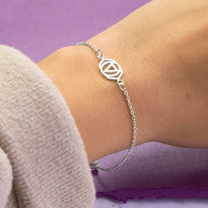 Könnte beinhalten: Ein silbernes Kettenarmband mit einem silbernen Anhänger, der das Symbol für das dritte Auge darstellt.