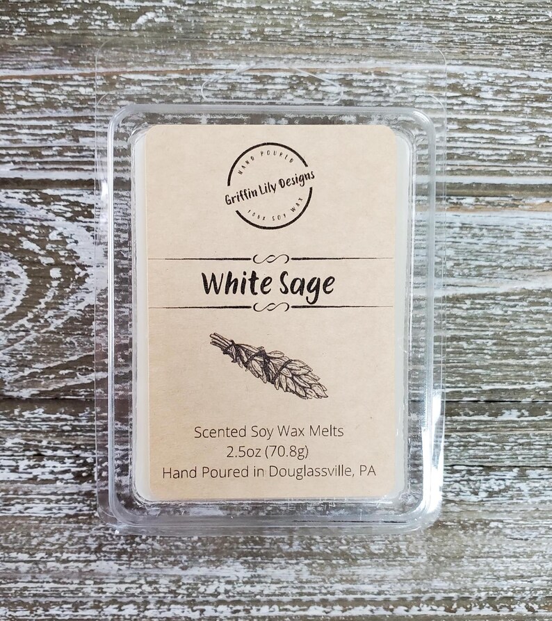May include: A clear plastic container with a brown label that reads "Griffin Lily Designs" and "White Sage". The label also includes the text "Scented Soy Wax Melts 2.5oz (70.8g) Hand Poured in Douglassville, PA".