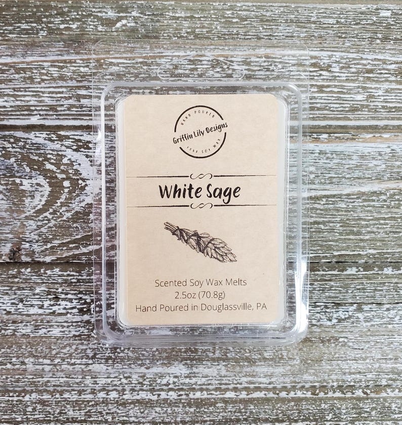 May include: A clear plastic container with a brown label that reads "Griffin Lily Designs" and "White Sage". The label also includes a drawing of a bundle of white sage and the text "Scented Soy Wax Melts 2.5oz (70.8g) Hand Poured in Douglassville, PA".