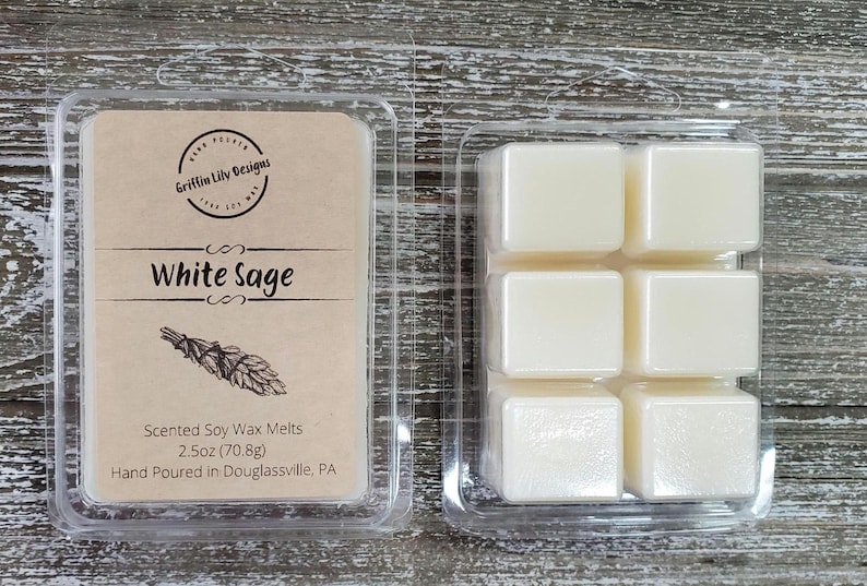 May include: A clear plastic package of six white soy wax melts, labeled "White Sage" with a drawing of a bundle of sage. The package also includes the text "Scented Soy Wax Melts 2.5oz (70.8g) Hand Poured in Douglassville, PA."