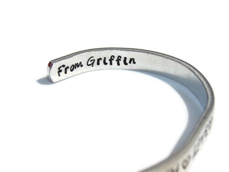 May include: A silver bracelet with the inscription "From Griffin" on the inside.