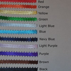 May include: A collection of fifteen horizontal picot edge ribbons in various colors including light pink, pink, red wine, red, orange, yellow, green, light blue, blue, navy blue, light purple, purple, brown, black, white, and off-white.