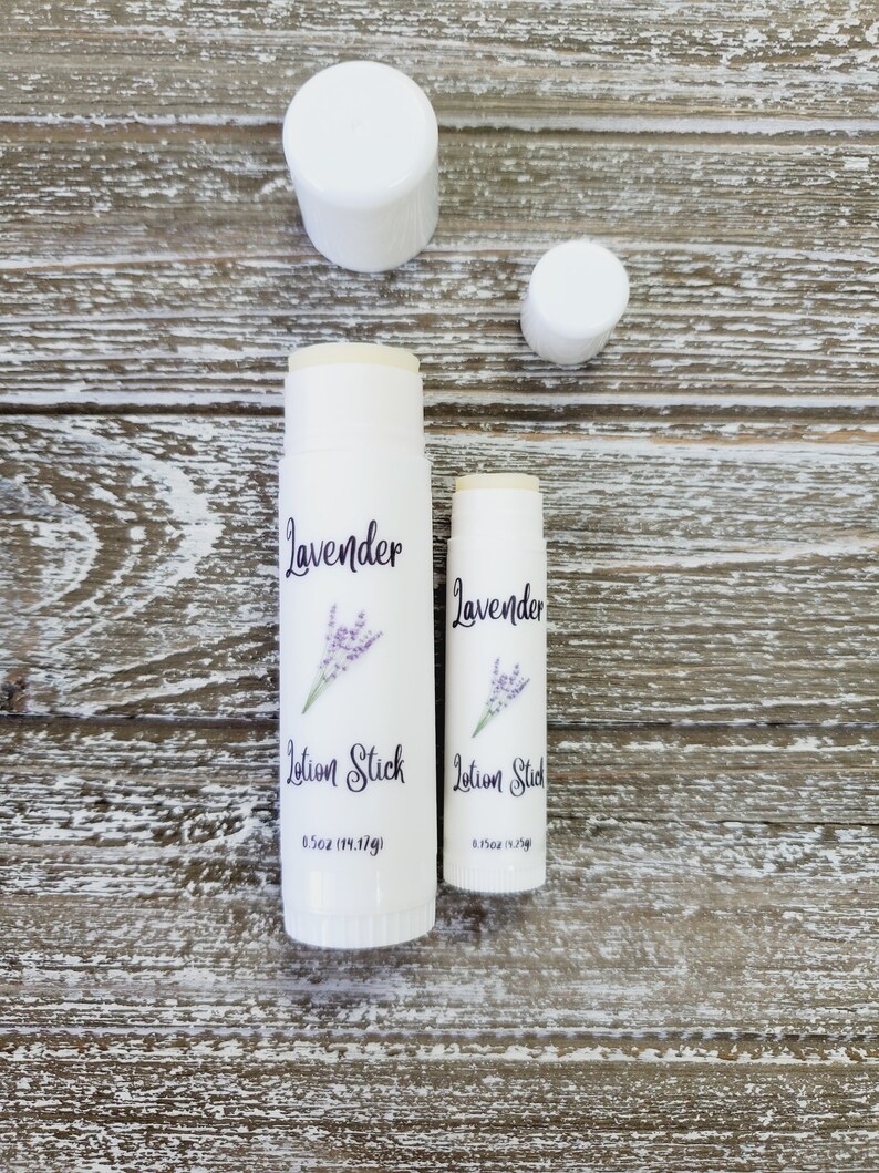 Pode incluir: Dois bast&otilde;es de lo&ccedil;&atilde;o brancos com a palavra "Lavanda" e um gr&aacute;fico de raminho de lavanda. O texto "Lotion Stick" est&aacute; abaixo da palavra "Lavanda". O bast&atilde;o maior tem 14,17g. Duas tampas brancas tamb&eacute;m est&atilde;o na imagem.