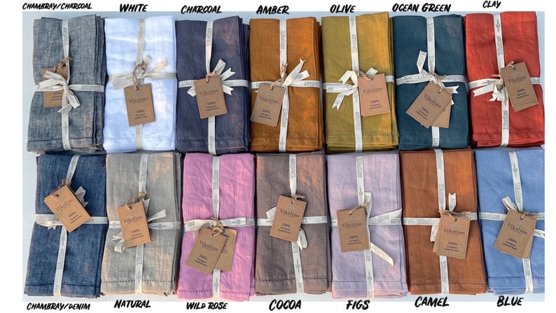 K&ouml;nnte beinhalten: Set mit 14 Leinenservietten in verschiedenen Farben, darunter Chambray/Anthrazit, Wei&szlig;, Anthrazit, Bernstein, Oliv, Ozeanblau, Ton, Chambray/Denim, Natur, Wildrose, Kakao, Feigen, Kamel und Blau. Jede Serviette ist mit einem Band gebunden und hat ein kleines Etikett mit dem Markennamen.