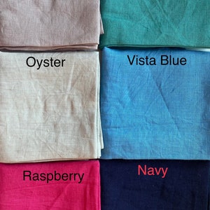 May include: A collection of six fabric swatches in various colors. The colors include "Figs", a light mauve; "Lagoon", a teal green; "Oyster", a light beige; "Vista Blue", a light blue; "Raspberry", a bright pink; and "Navy", a dark blue.