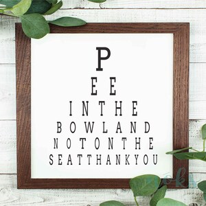 May include: A framed print with a black and white eye chart that reads "Pee in the bowl and not on the seat thank you".