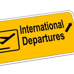 May include: Yellow sign with a white border and black text that reads "International Departures". A black airplane icon is in the top left corner of the sign. A black arrow points upwards.