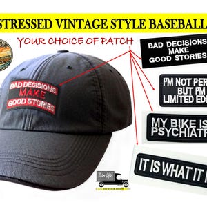 May include: A dark grey baseball cap with a rectangular patch featuring the white and red text BAD DECISIONS MAKE GOOD STORIES. Additional rectangular patches are displayed with text including I'M NOT PERFECT BUT I'M A LIMITED EDITION.