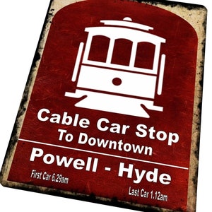 Könnte beinhalten: Ein rotes Schild im Vintage-Stil mit einem weißen Kabelbahnsymbol. Das Schild lautet "Cable Car Stop To Downtown Powell - Hyde" mit den Zeiten "First Car 6:29am" und "Last Car 1:12am".