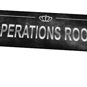 Peut inclure: Une pancarte noire et blanche avec une couronne argentée et le texte "OPERATIONS ROOM" en lettres argentées.