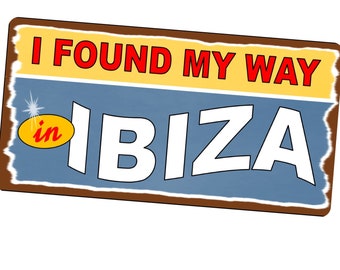 May include: A blue and yellow sign with the text "I found my way in IBIZA" in white letters. The sign has a brown border and a distressed look.