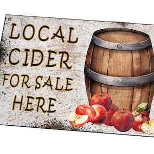 Könnte beinhalten: Ein rustikales Holzschild mit dem Text "LOCAL CIDER FOR SALE HERE" in gelber Schrift. Ein Holzfass mit Metallbändern liegt auf dem Schild, mit roten Äpfeln drumherum.