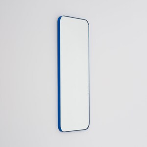 May include: A tall, rectangular mirror with a bright blue frame. The mirror has rounded corners and a modern design.
