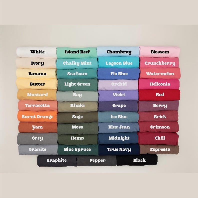 Pu&ograve; includere: Un'esposizione di tessuti piegati in vari colori, ciascuno etichettato con il nome del colore corrispondente. I colori includono bianco, avorio, banana, burro, senape, terracotta, arancione bruciato, igname, grigio e granito.