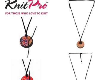 Puede incluir: Un collar negro con un colgante de madera. El colgante es redondo y tiene un patrón de veta de madera roja y marrón. El colgante está decorado con gomas elásticas de colores. El collar es un portaherramientas de tejido.