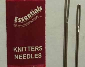 May include: A red and white package of knitting needles. The package says "Essentials All your knitting needs" and "Knitters Needles". The package also includes the brand name, address, and postal code. Two silver knitting needles are shown next to the package.