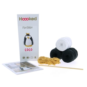 May include: Crochet kit to make a penguin amigurumi. The kit includes white, black, and yellow yarn, a crochet hook, and instructions. The box features a picture of the finished penguin with the text "Hoooked Penguin Coco".