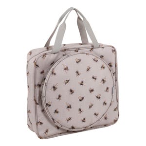 Peut inclure: Un sac fourre-tout beige avec un motif répété d'abeilles marron et noires. Le sac a un compartiment circulaire à l'avant et des poignées grises. Conçu pour transporter des objets.