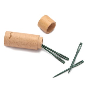 Peut inclure: Un ensemble de quatre aiguilles en bois vert avec un étui de rangement en bois. L'étui est marqué "KnitPro".