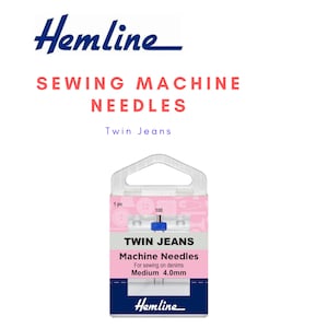 Könnte beinhalten: Eine Packung Hemline Twin Jeans Maschinennadeln zum Nähen von Jeansstoffen. Die Verpackung ist rosa und weiß mit dem Text "Twin Jeans" und "Medium 4,0 mm". Das Hemline-Logo befindet sich oben und unten.