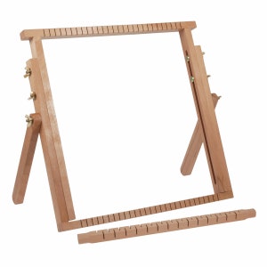 Op de afbeelding: Een houten weefgetouw met een rechthoekig frame en verstelbare poten. Het weefgetouw is gemaakt van natuurlijk hout en heeft een eenvoudig ontwerp.
