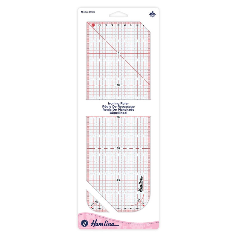 May include: A white ironing ruler with a grid pattern and a diagonal line. The ruler is labeled "Ironing Ruler, R&egrave;gle De Repassage, Regla De Planchado, B&uuml;gellineal" and is 10 cm by 30 cm. The ruler is packaged in a clear plastic sleeve with a pink and white border.