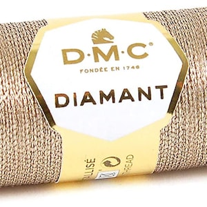 May include: A spool of gold metallic thread with a label that reads "DMC Diamant" and "Fond&eacute;e en 1746".