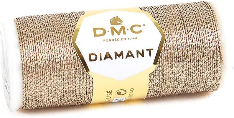 May include: A spool of gold metallic thread with a label that reads "DMC Diamant" and "Fond&eacute;e en 1746".