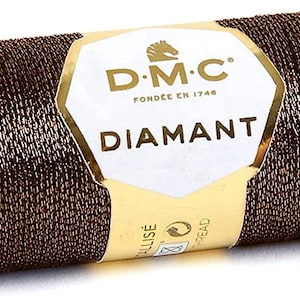 May include: A spool of brown metallic thread with a gold label that reads "D.M.C. Fond&eacute;e en 1746 Diamant".