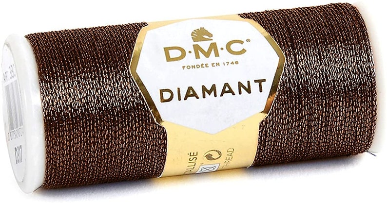 May include: A spool of brown metallic thread with a gold label that reads "D.M.C. Fond&eacute;e en 1746 Diamant".