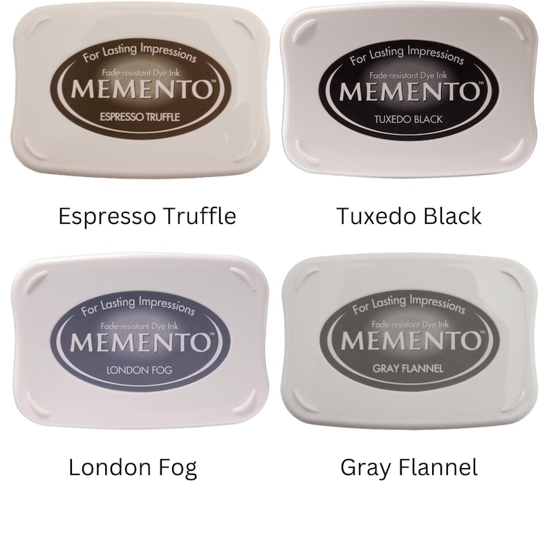 Pode incluir: Quatro almofadas de tinta para carimbar, cada uma com uma cor diferente. As almofadas de tinta s&atilde;o etiquetadas como "Espresso Truffle", "Tuxedo Black", "London Fog" e "Gray Flannel". Cada almofada de tinta tem as palavras "For Lasting Impressions" e "Fade-resistant Dye Ink" impressas nela, juntamente com a palavra "MEMENTO" em uma fonte estilizada.