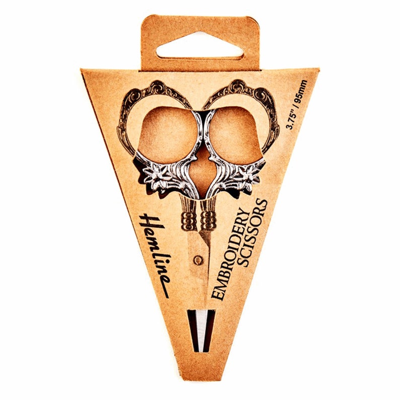 May include: A pair of silver embroidery scissors with ornate handles in a cardboard packaging. The packaging is brown and has the text "Hemline Embroidery Scissors" and "3.75" / 95mm" printed on it.