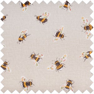 Puede incluir: Una tela beige con un patr&oacute;n repetido de abejas negras y amarillas con acentos florales.