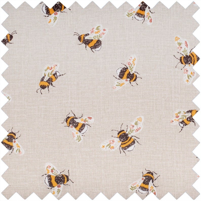 Puede incluir: Una tela beige con un patr&oacute;n repetido de abejas negras y amarillas con acentos florales.